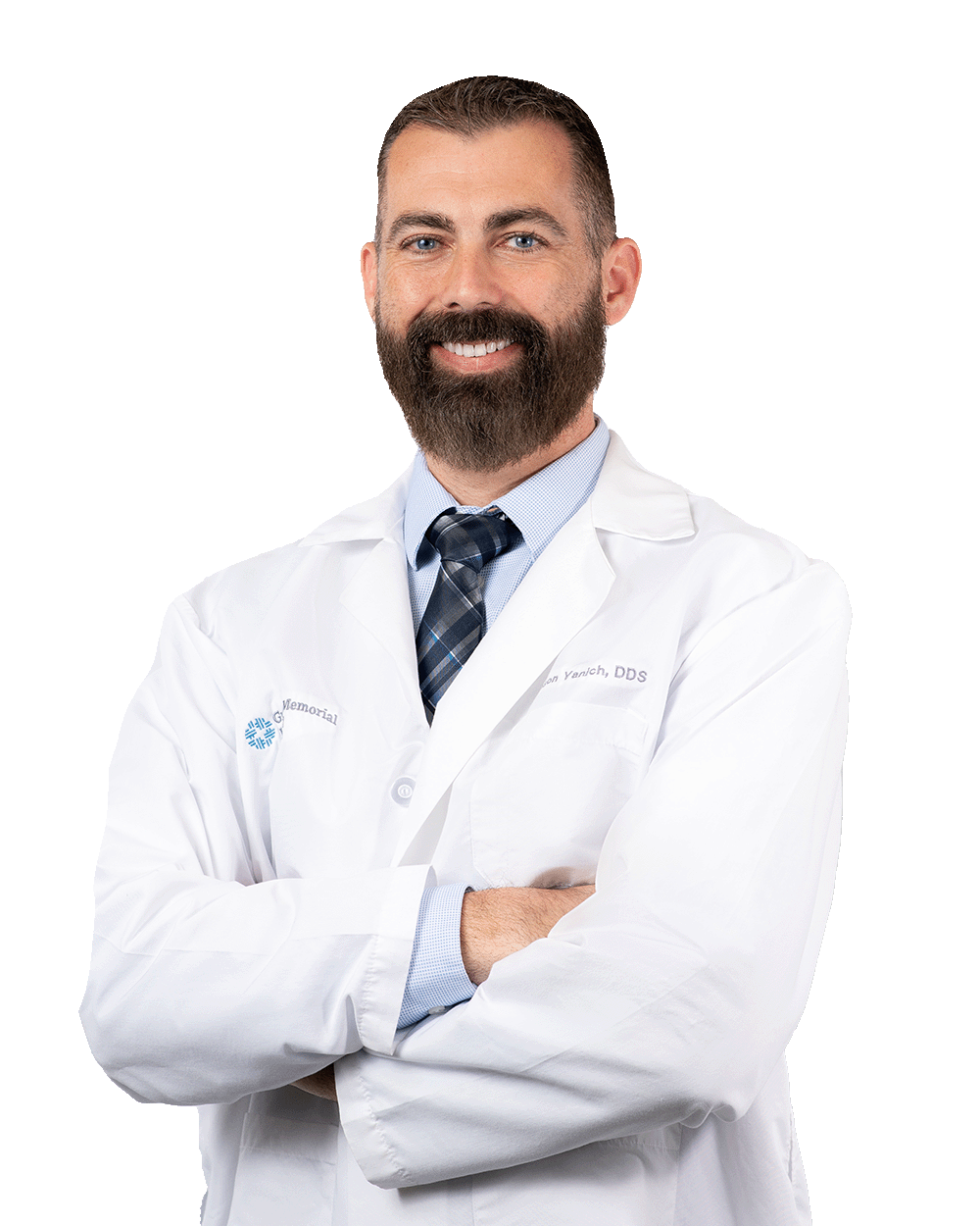 Headshot of Dr. Yanich, wearing a white lab coat and tie, standing confidently with arms crossed, representing expert dental care and patient-focused service