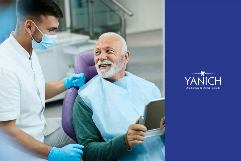Image of a male patient sitting in a dental chair while a dentist examines his teeth and discusses treatment options